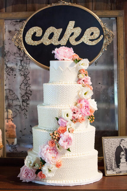 Γαμήλια τούρτα με διάφορα φρέσκα λουλούδια.